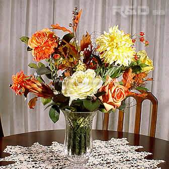 Autumnal silk flowers arranged in a crystal vase