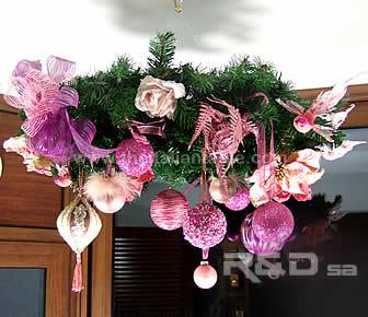 Ceiling wreath for holiday season, decorated with pink balls, butterflies, flowers, birds