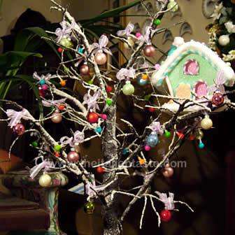 Original little Christmas tree made with snowy leafless branches, decorated with balls and LED lights 