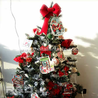 Synthetic pine tre decorated with santa images, red bows and other decor
