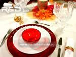 tavola di Natale nei toni rosso e arancio, molto calda e invitante