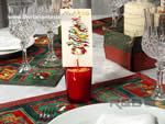 segnaposto natalizio realizzato con un bicchierino di vetro colorato ripieno di sabbia con un cartellino con il nome