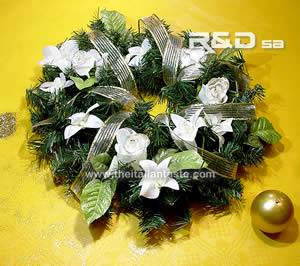 a ring centerpiece with white flowers and pine