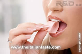 giovane donna che si porta alla bocca una gomma americana da masticare