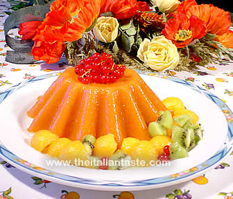 gelatina di anguria, dolce tipicamente estico. La foto mostra un budino arancione  circondato da frutta fresca
