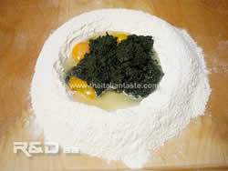 Flour with a well and inside ingredients for egg pasta