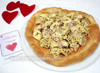 tortellini panna e prosciutto serviti su una base di pasta sfoglia a forma di cuore, ideali per il menu di San Valentino