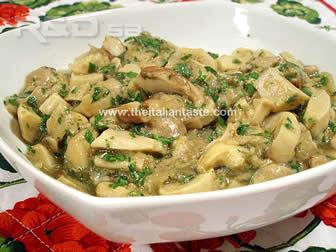 Mushrooms cooked with olive oil, parsley and garlic in a white bowl