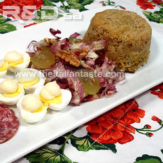 starter made with salami slices, quail eggs garnished with mayonnaise, chicory-and-fruit  salad, zucchini blossom flan