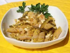 Shrimp penne on a white bowl, garnished with parsley and crumbled eggs
