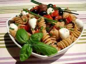 pasta salad, Caprese-style - the image shows short pasta dressed with fresh tomatoes, black olives, mozzarella and basil according to Capri-style