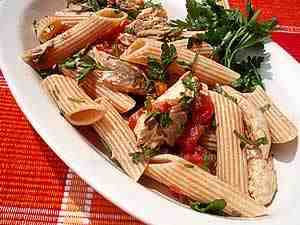 cold pasta with mackerel and tomatoes, the photo shows a detail of pasta dressed with mackerel pieces and tomato pieces