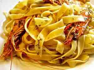 Tagliatelle with king prawns, Italy-style. The photo shows a dish filled of pasta dressed with aromatic herbs and king prawn sauce