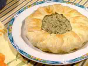italian savoury pie with ricotta, tuna and courgettes. The image shows the whole pie on a serving plate