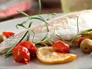 Baked sea bass ready to eat accompanied by cherry tomatoes and olives