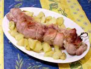 stuffed rabbit accompanied by stewed potatoes in a serving platter