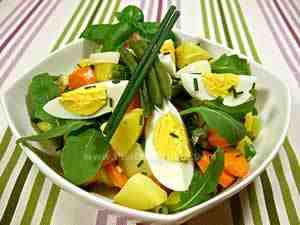 Summer salad with green beans, potatoes, rocket, carrots and eggs