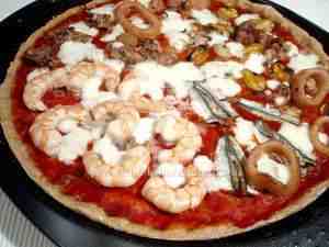 Seafood pizza, the photo shows a detail of the pizza surface with prawns, anchovies, flying squids, mussels and clams