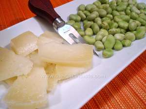 Fava beans (called also broad beans) and pecorino cheese, the photo shows the shelled fava beans, pecorino cut into bite-sized morsels and a glass full of red wine to match this appetizer