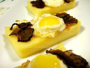 polental slices, decorated with fried quail eggs and slices of black truffle in oil