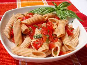 pasta salad, summer dish with penne dressed with ripe tomatoes, basil, chives and olive oil