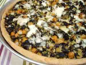 Savory tart filled with a mixture of cod, chickpeas, kale and garnished with mozzarella