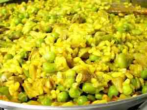 Close-up of paella with peas, fava beans, artichokes and asparagus