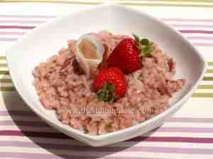 Risotto with strawberries and speck ham on a white bowl
