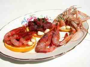 assorted platter that consists of raw shrimps, scampi and tuna tartare