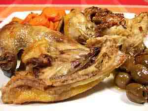 Guinea fowl, cooked in the pot, is served accompanied by olives and carrots