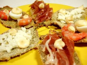 tartine di salvia guarnite con gamberi, prosciutto e uova di quaglia