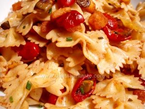 Farfalle condite con sugo rosso di pomodori, olive e l'aggiunta di crostini